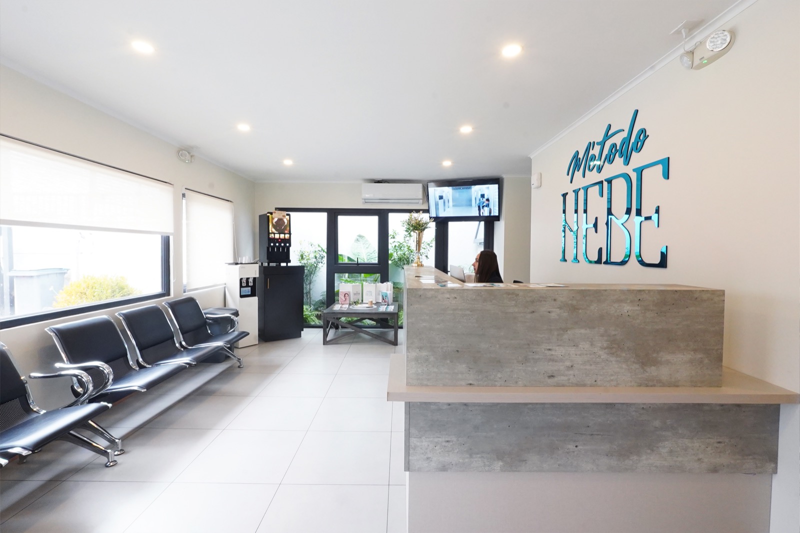 Sala de espera y recepción de la clínica Método Hebe en Los Ángeles con pantalla informativa